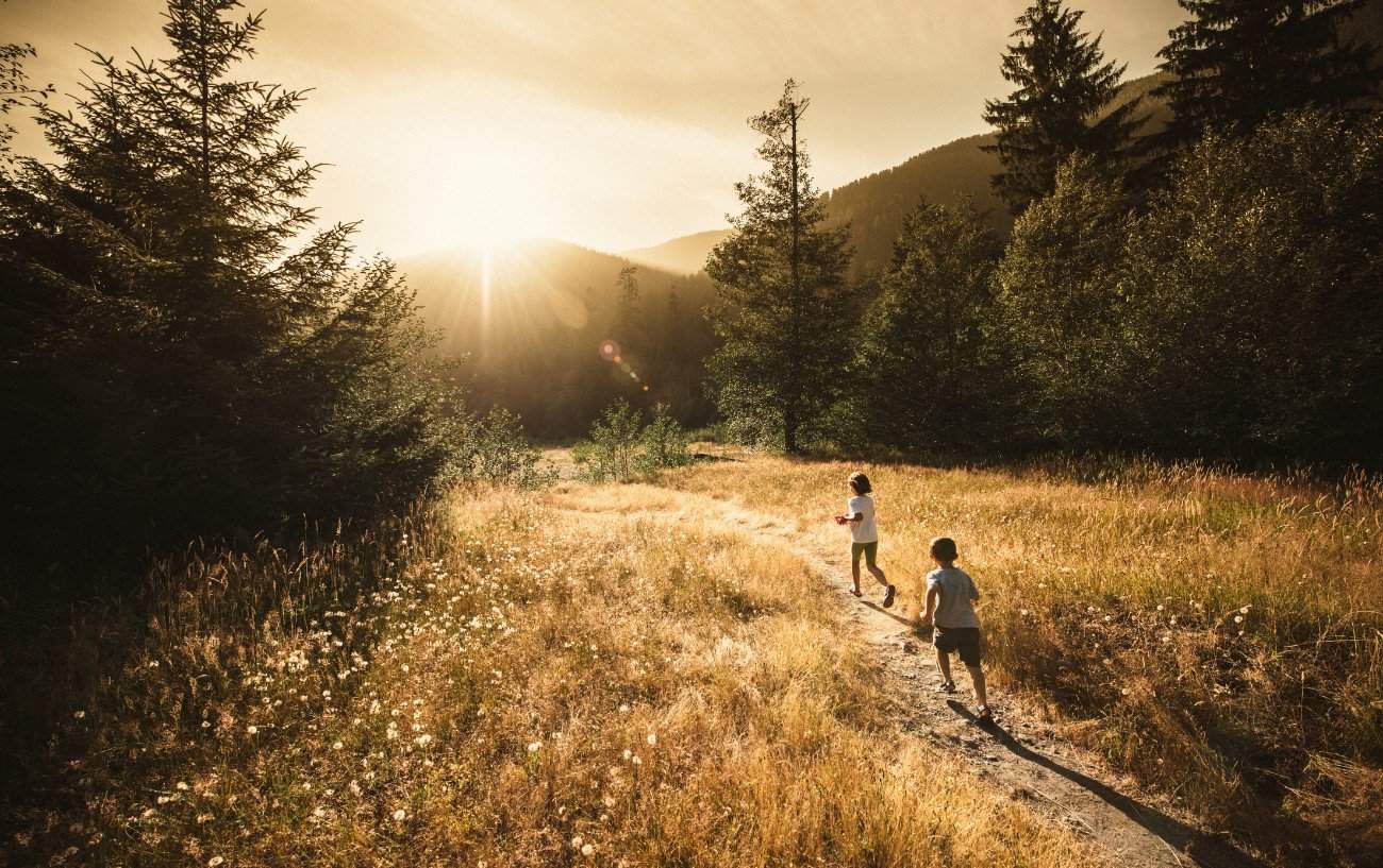 kids running in a field in sunset