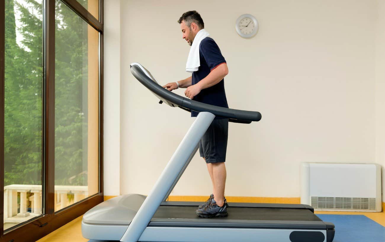 Man getting ready to go on a treadmill. 