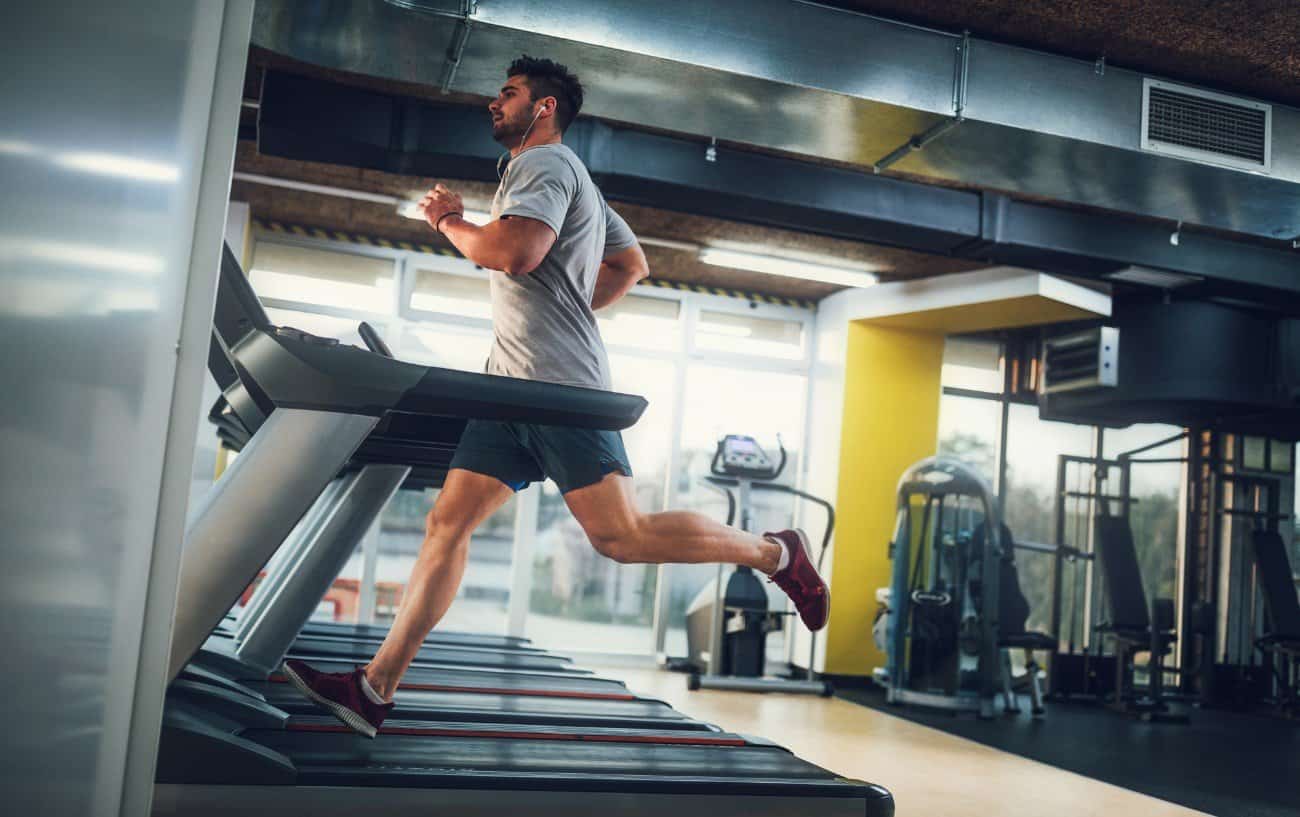 Man running on a treadmill in a gym. 