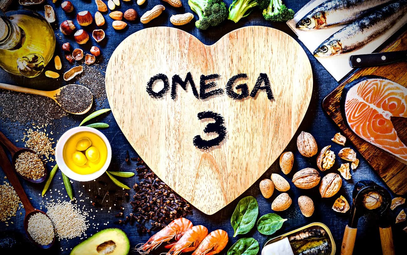 A sign that says "omega 3", surrounded by fish, seeds, shellfish, nuts, oil and avocado. 