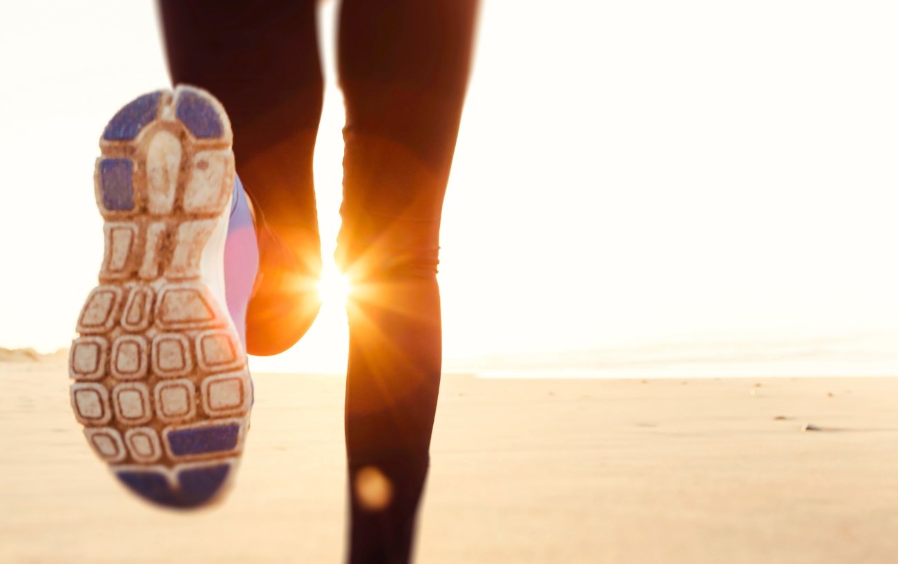 Closeup of sneakers running on a beach