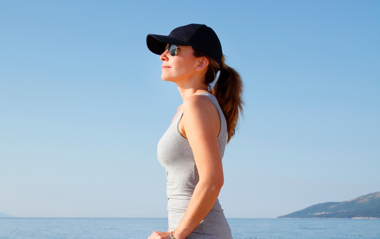 Woman with cap next to sea
