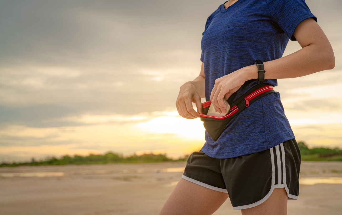 woman putting phone in fanny pack