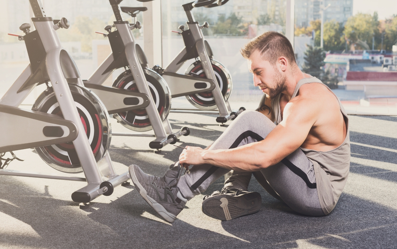 man tying up shoes in gym