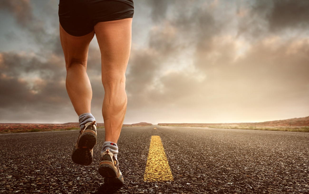 man running on road with clouds